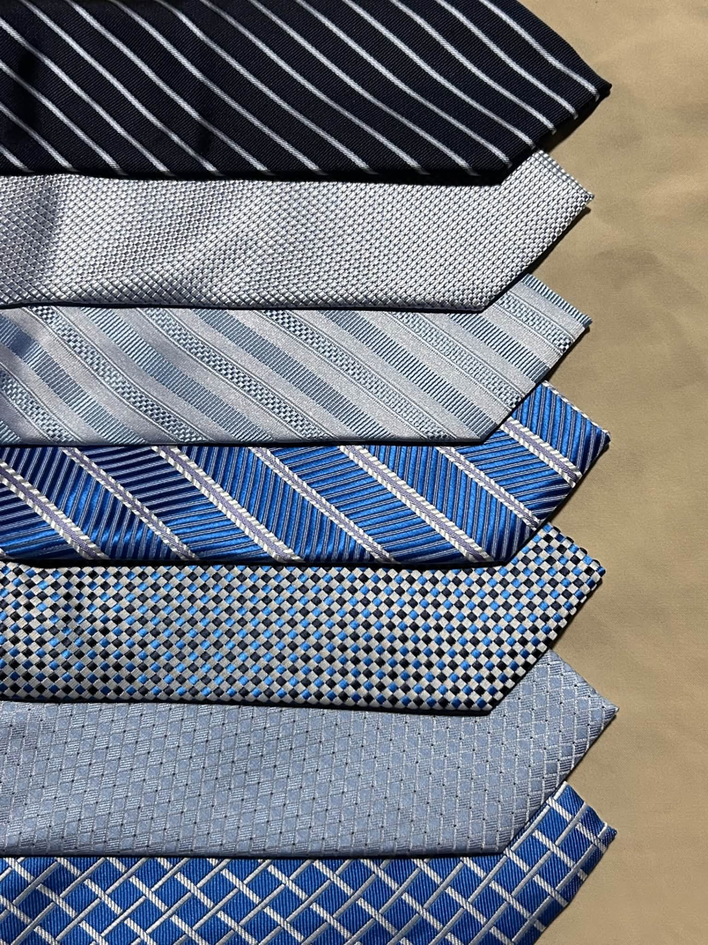 Stack of navy, silver, and blue patterned neckties