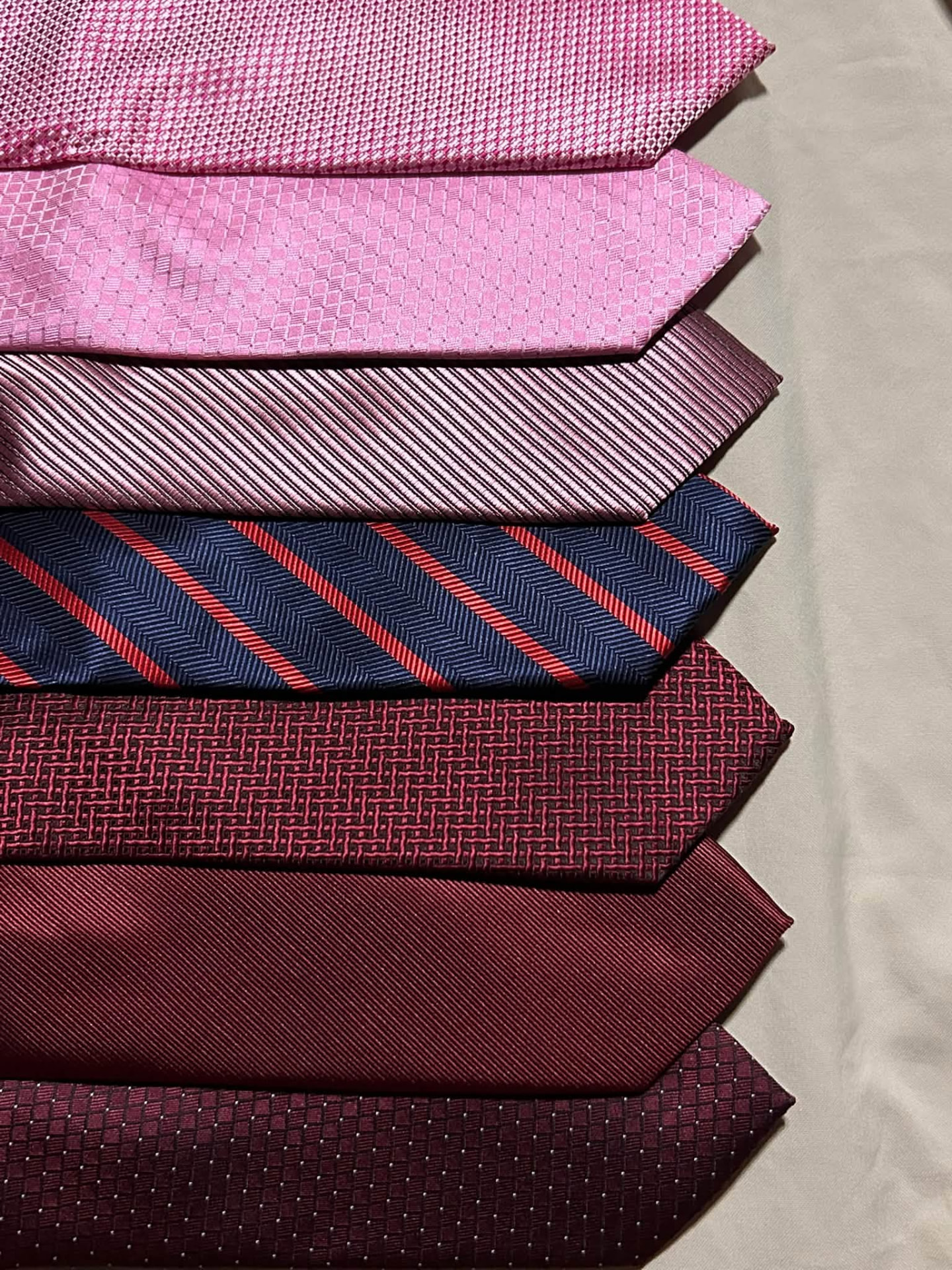 Stack of pink, burgundy, and navy neckties