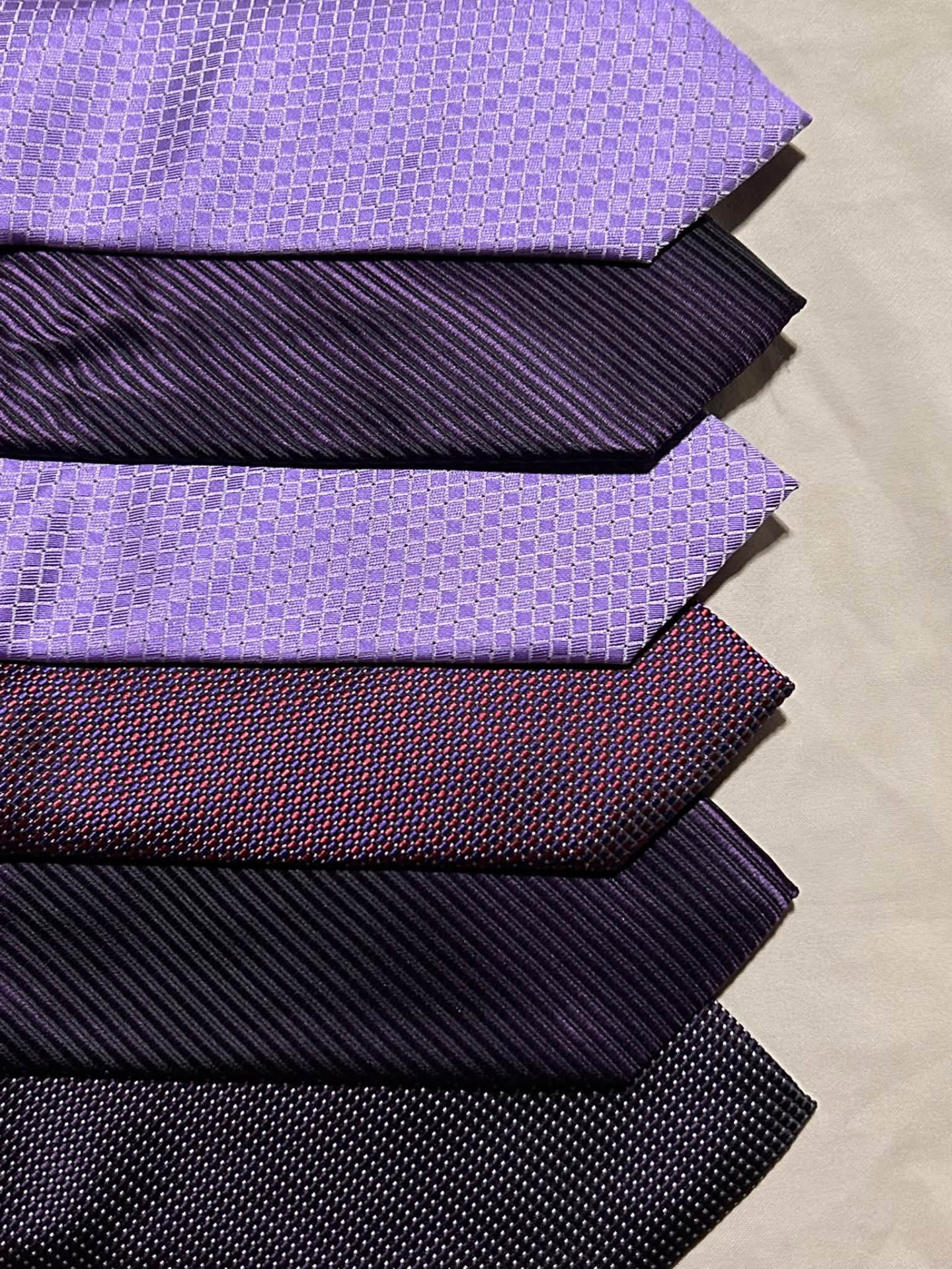 Stack of lavender, violet, and deep plum neckties